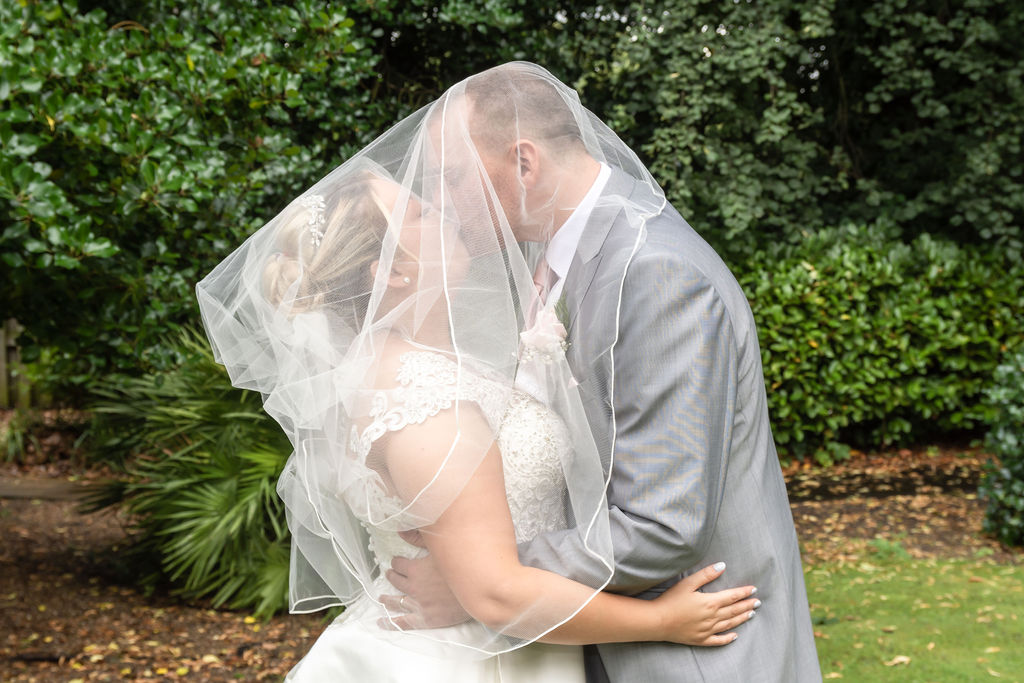 Liverpool lovebirds seal the deal with a romantic kiss beneath flowing veil. #LiverpoolWedding #VeiledKiss #WeddingPhotography