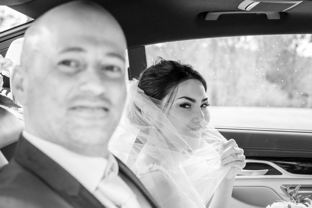 Runcorn Wedding Bliss: Bride Veiled in Joy beside Groom in Classic Car at Town Hall #RuncornWedding #WeddingPhotography