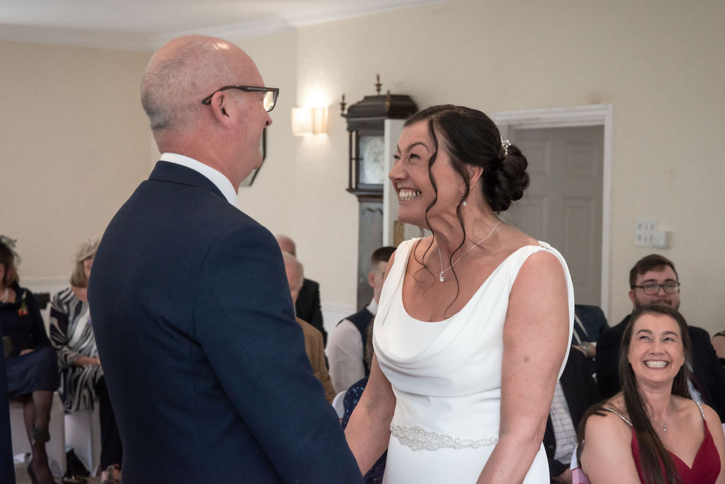a happy bride, a happy bridesmaid during a wedding ceremony at Ridgemont House in Horwich, photography by award winning wedding photographer Michael Pardoe