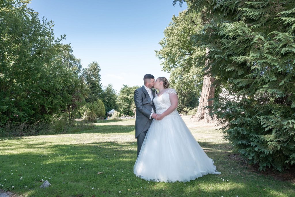 Picture perfect: Bride & groom share a romantic kiss at Highfield Hall. Capture your love story today! #WeddingInspo #LoveWins